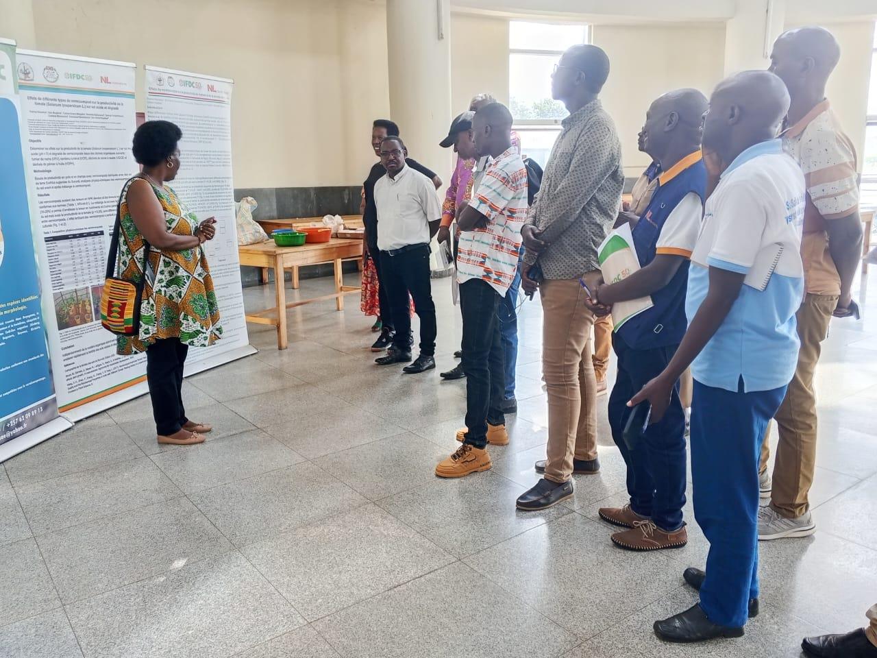 Présentation d'un poster de recherche lors de la visite de l'IFDC