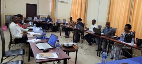Participants réunis autour de tables en U avec ordinateurs